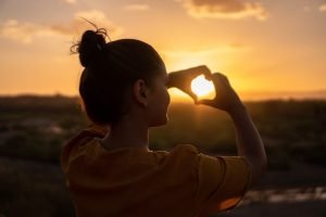 Sonnenbrand_Tipps-zur-Behandlung-und-Vorbeugung_Frau-geniesst-Sonnenuntergang_2022